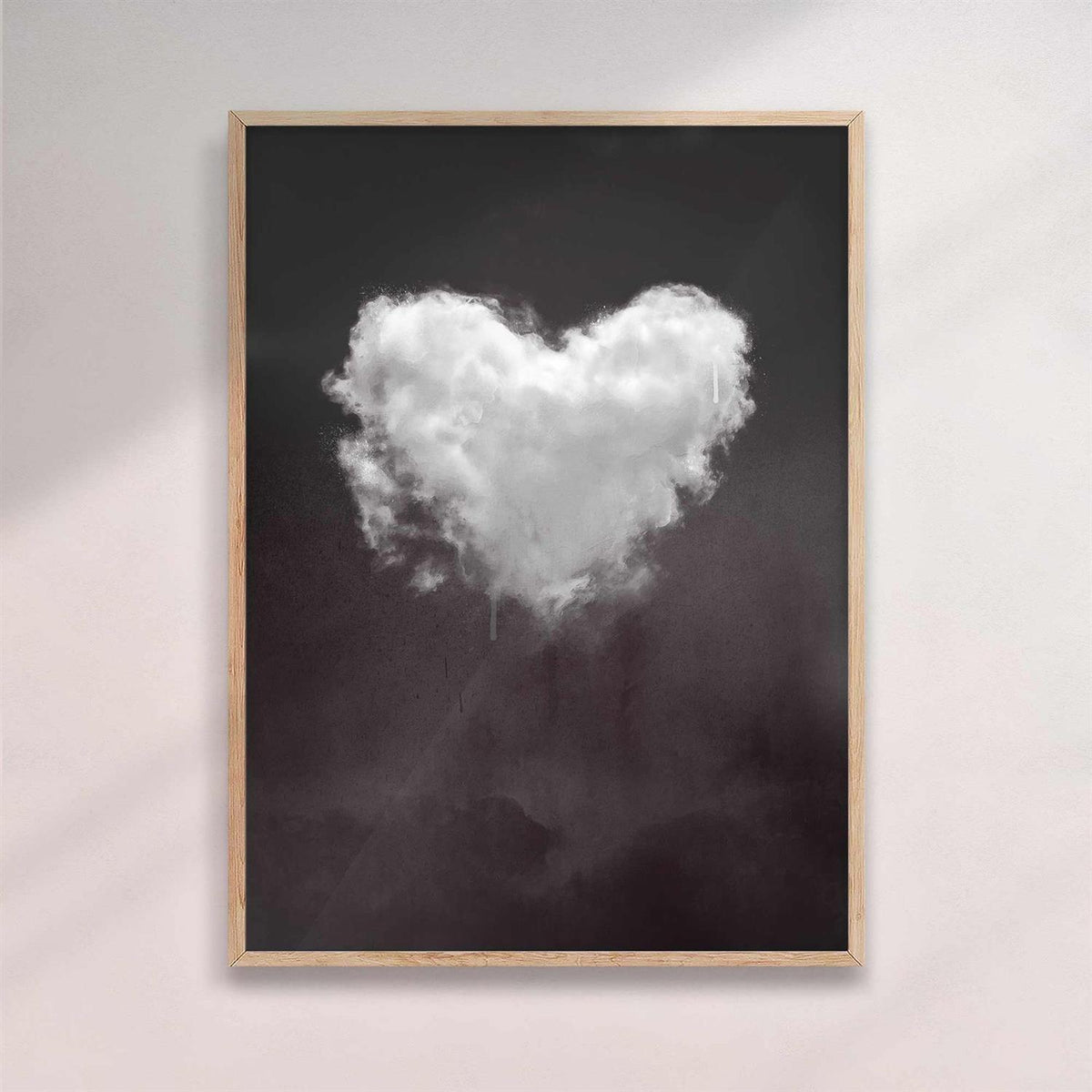 Framed artwork of a heart-shaped cloud on a dark background with natural/oak frame