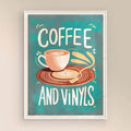 Framed artwork with a coffee cup and vinyl record design on a teal background and white frame