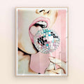 Framed artwork of a person's mouth holding a disco ball against a light pink background with natural/oak frame