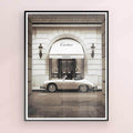 Framed artwork of a classic car in front of a Cartier store entrance on black frame.