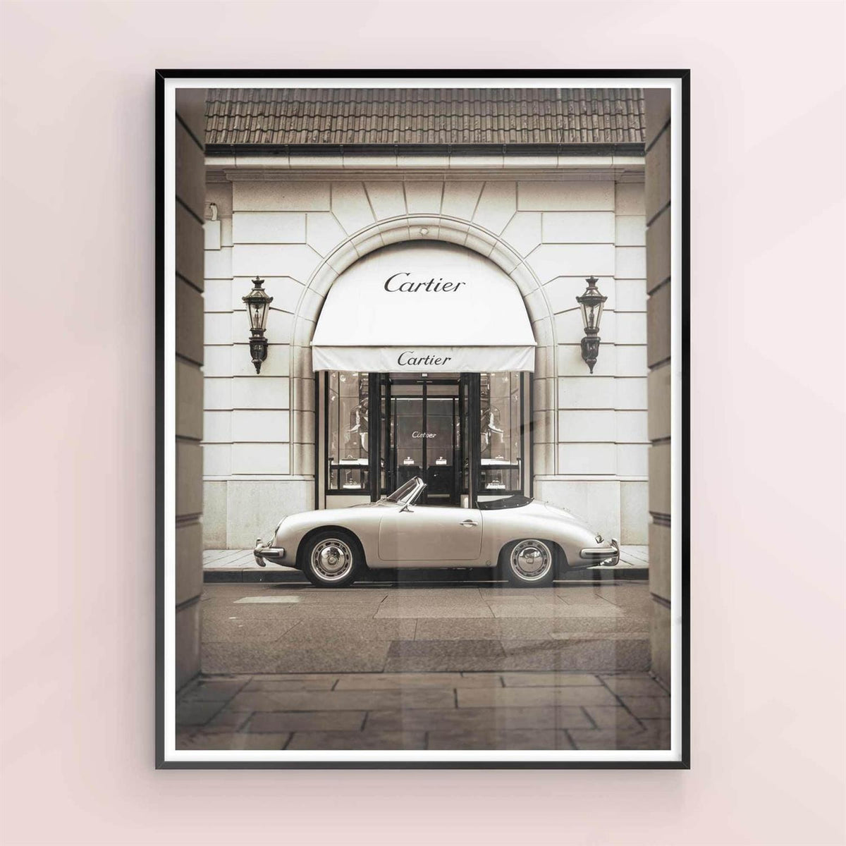 Framed artwork of a classic car in front of a Cartier store entrance on black frame.