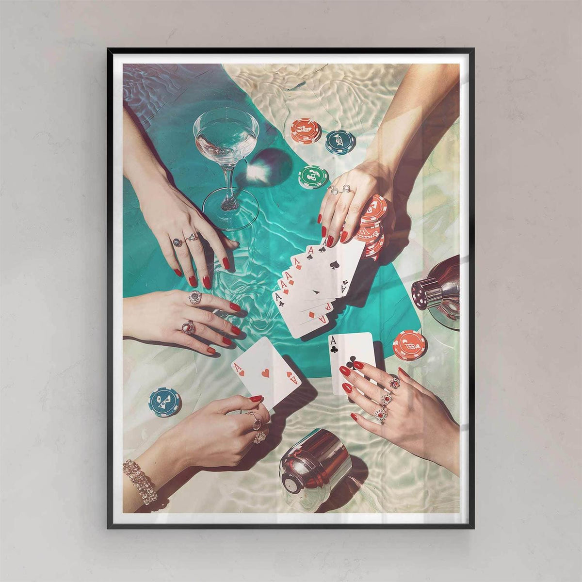 Framed artwork of hands playing cards with drinks and chips on a table with black frame
